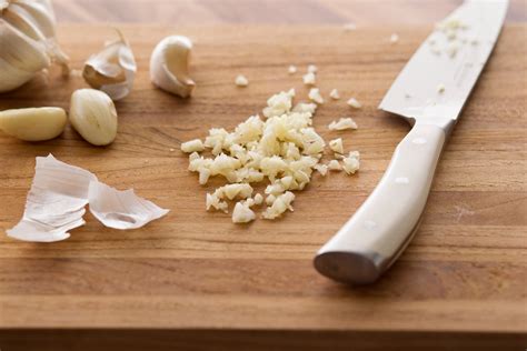 Here are the steps: Loosen the cloves of garlic from the head, using fingers. Remove the cloves of garlic from the head of garlic. Peel off the outer skin with your fingers, exposing the flesh of the garlic, and discard the skin. Rub the garlic clove up and down the grater until the garlic is grated.